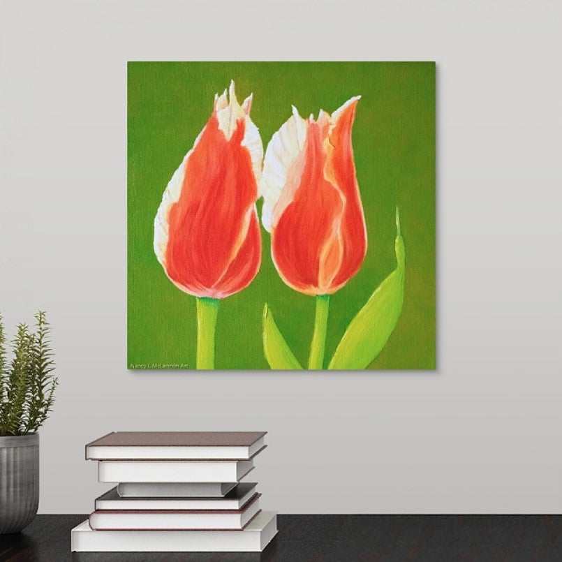 A painting of two sunlit orange tulips in full bloom with solid, vivid green  backdrop hanging over a black desk