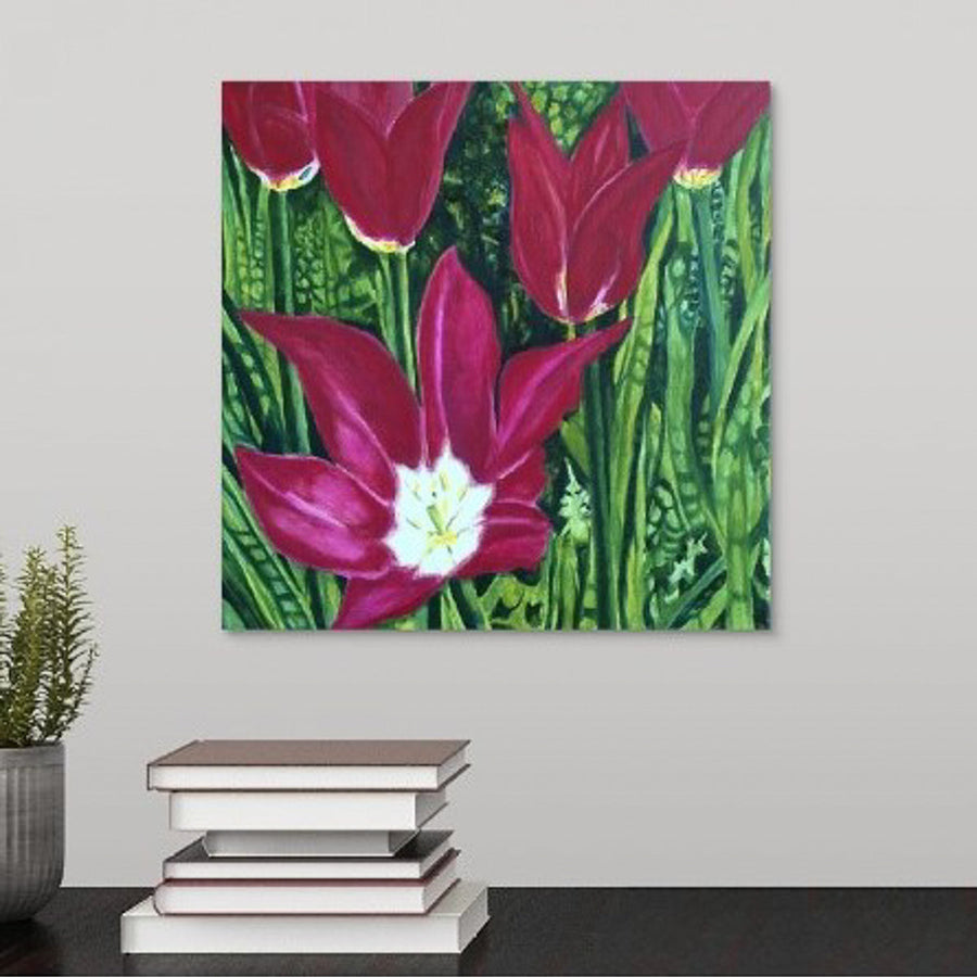 A painting of dark magenta tulips in full bloom, surrounded by a lush, vivid green garden backdrop hanging over desk