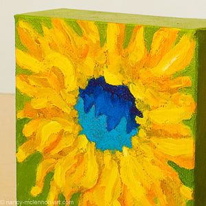 a painting by fine artist Nancy McLennon of a yellow sunflower with blue center on a bright green background detail