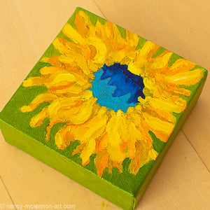 a painting by fine artist Nancy McLennon of a yellow sunflower with blue center on a bright green background overview