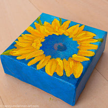 Load image into Gallery viewer, a painting by fine artist Nancy McLennon of a yellow sunflower with a blue center on dark blue background overview