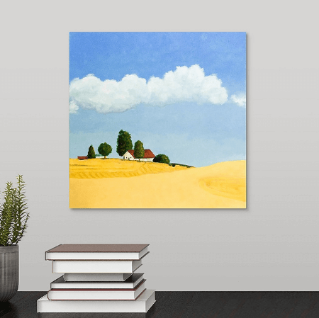 A painting of golden farm fields near Spokane, little red-roofed farmhouse, a clear blue sky with fluffy white clouds hanging over a black desk