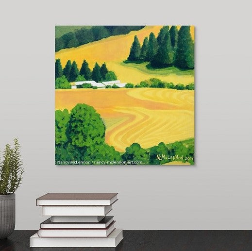 A painting of a sunny golden rows of harvested Washington State farm fields, white farm buildings which are surrounded by green trees hanging over a black desk