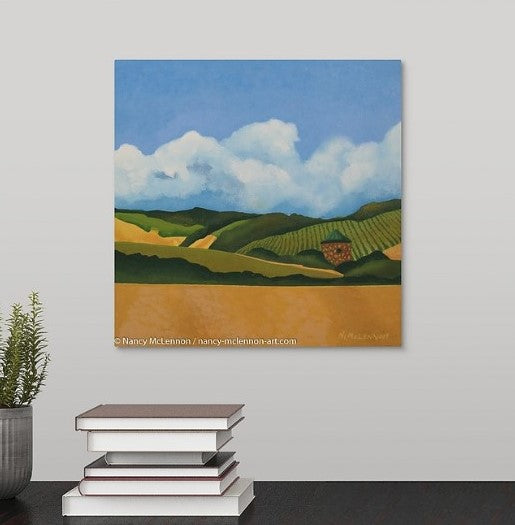 A painting of a Napa Valley, CA vineyard with golden hills and a stone hut with a copper roof hanging over a black desk