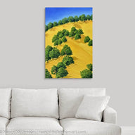 A painting of sunlit trees on the golden hillside that surrounding Lake Berryessa in the Napa Valley, California in summertime hanging on a white wall over a white couch